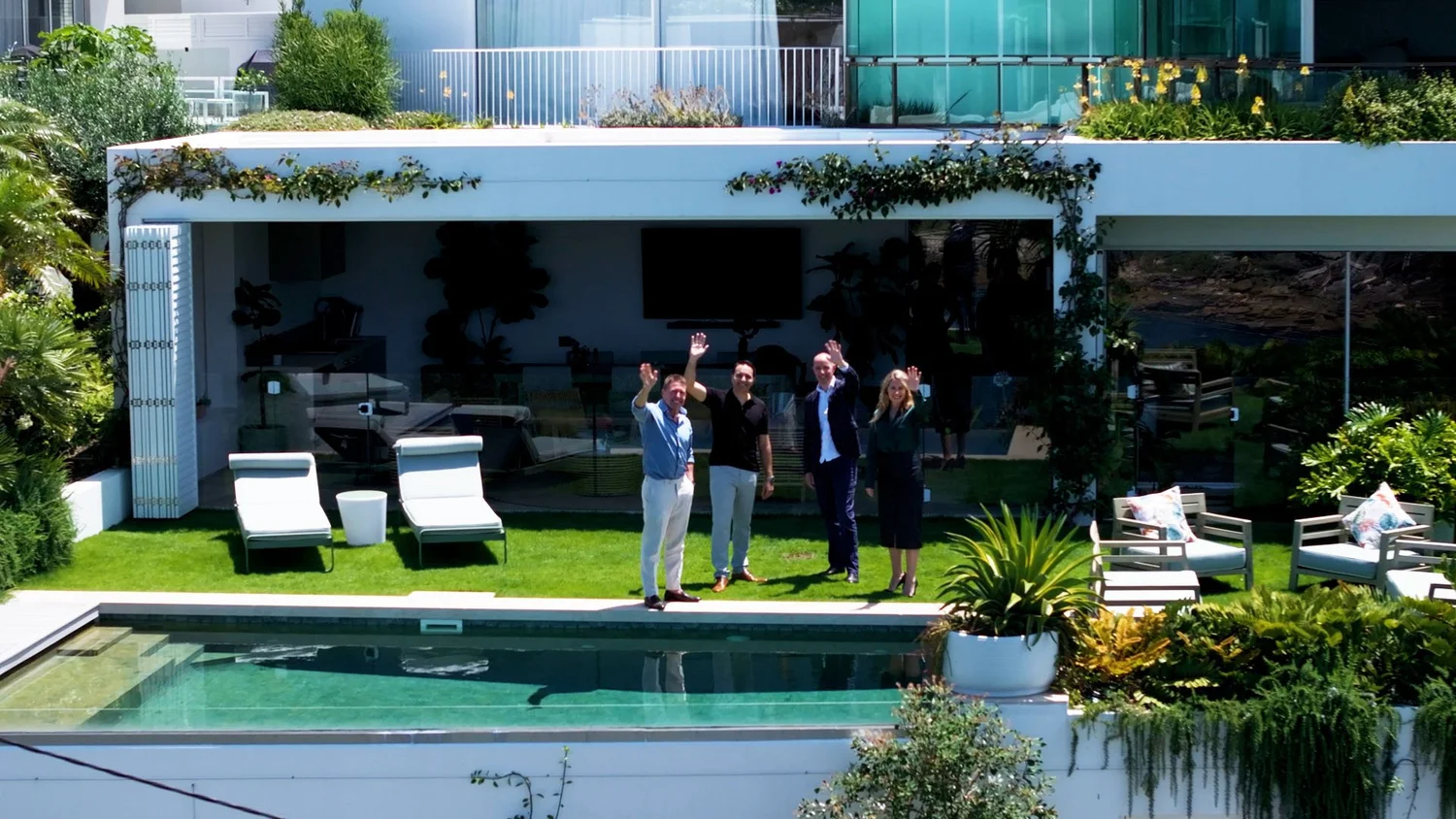 Providence Property Team waving at modern house with a pool and garden area.