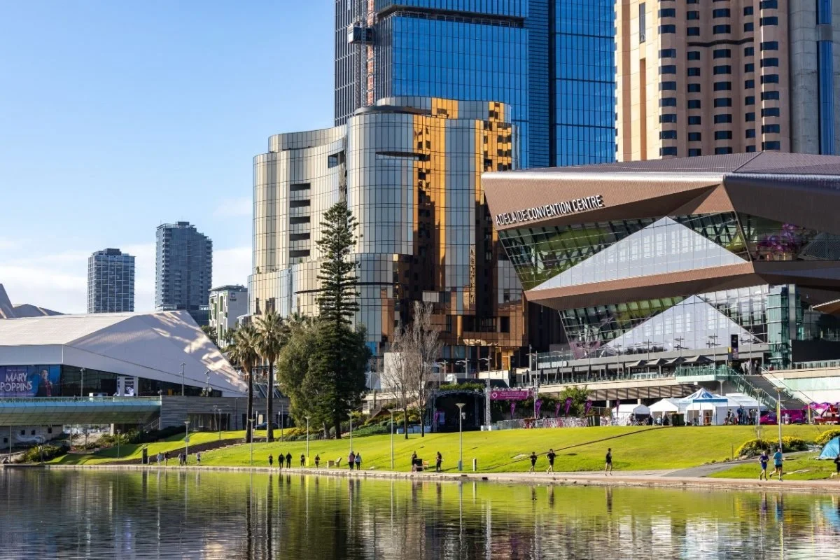 Modern skyline with the Adelaide Convention Centre and adjacent tall buildings, reflecting in a river.